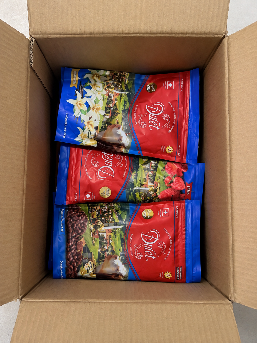 Caja de distribuidor abierta con sobres de Dulet en sus sabores vainilla, fresa y chocolate